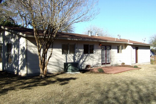 patio with flowering shrubs and shade trees