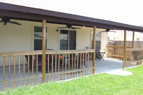 patio runs the width of the home and features lights and three ceiling fans