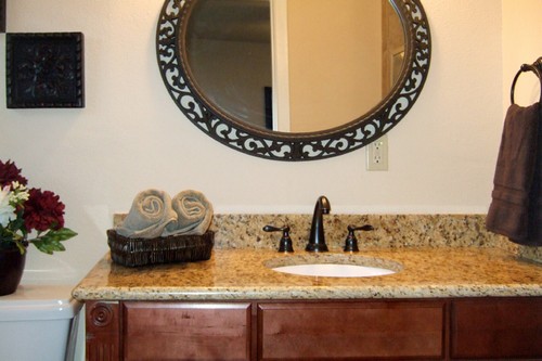 master bathroom with granite counter on the vanity and a tiled shower